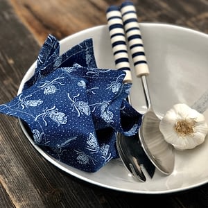 Protea Shweshwe Serviettes Blue with blue bowl and blue and white stripe salad servers.